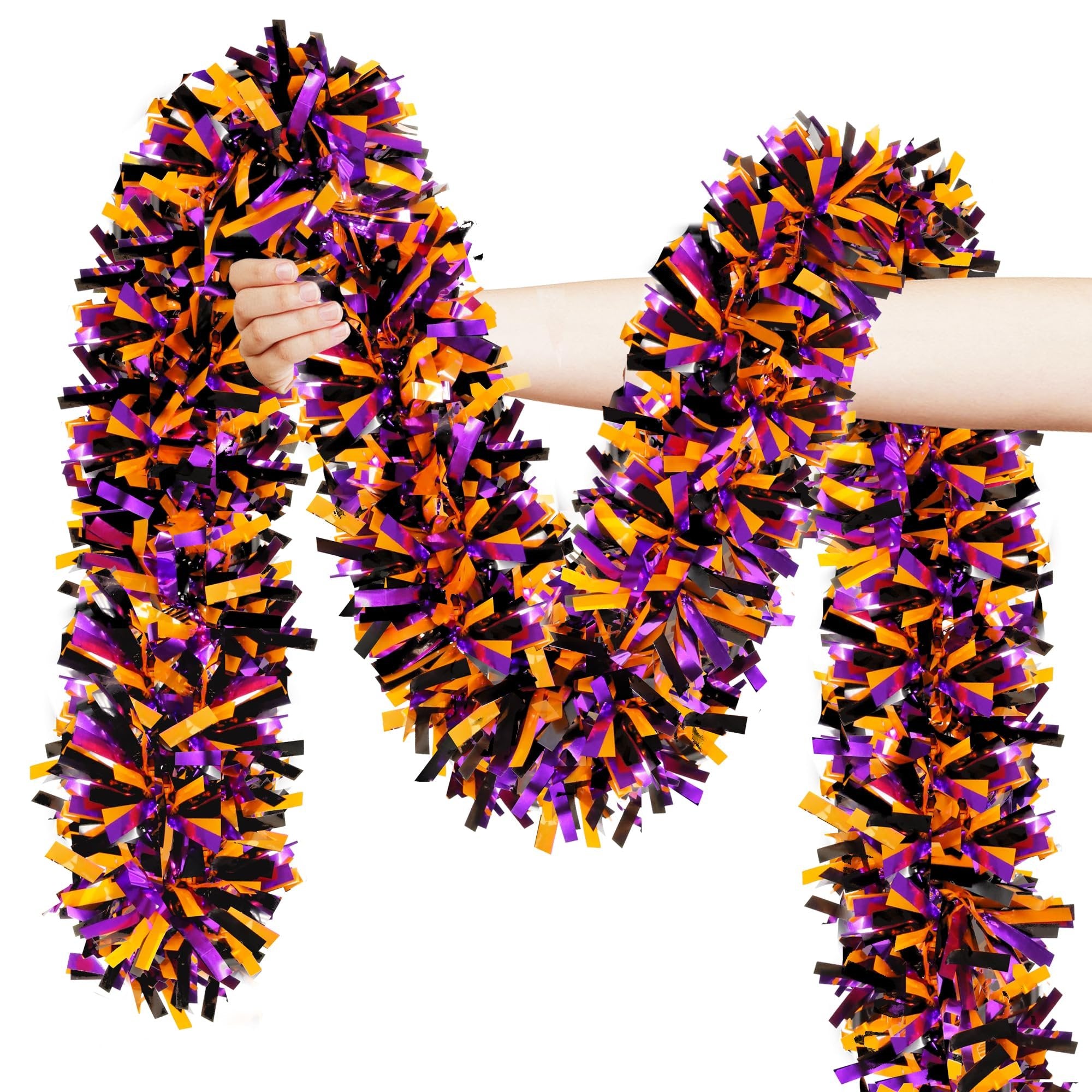 Hand holding orange, black, and purple metallic Halloween tinsel garland against a white background