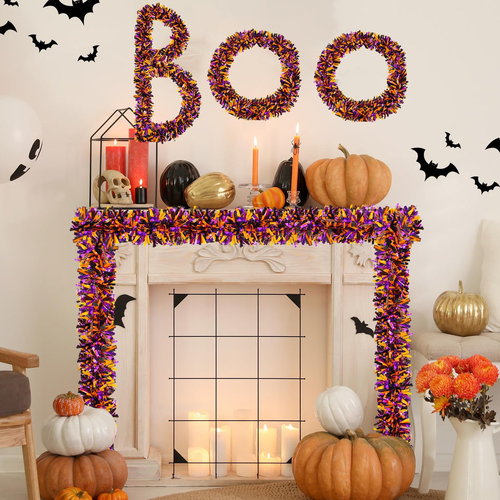 Halloween tinsel garland spelling BOO above a decorated fireplace with pumpkins and candles