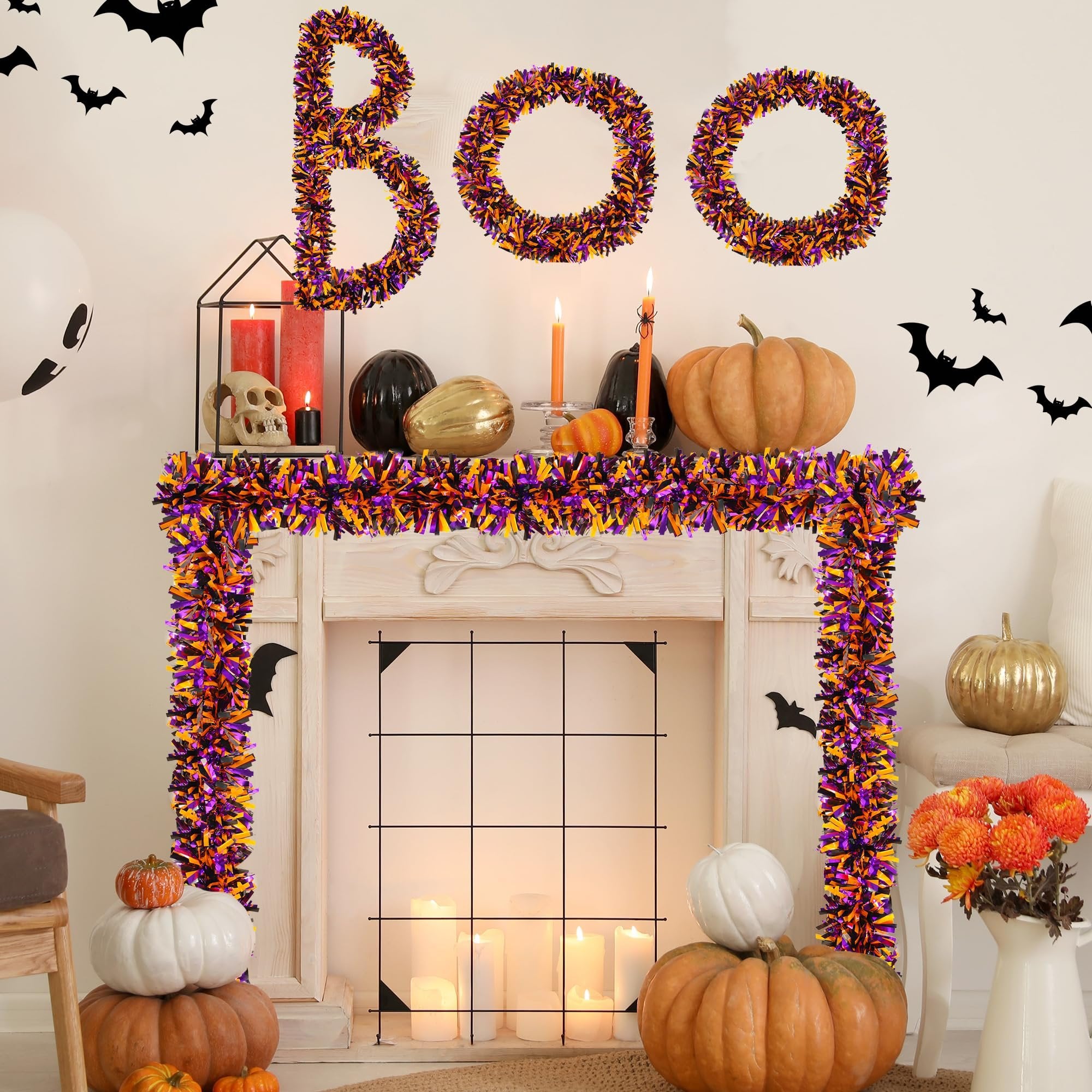Halloween tinsel garland spelling BOO above a decorated fireplace with pumpkins and candles