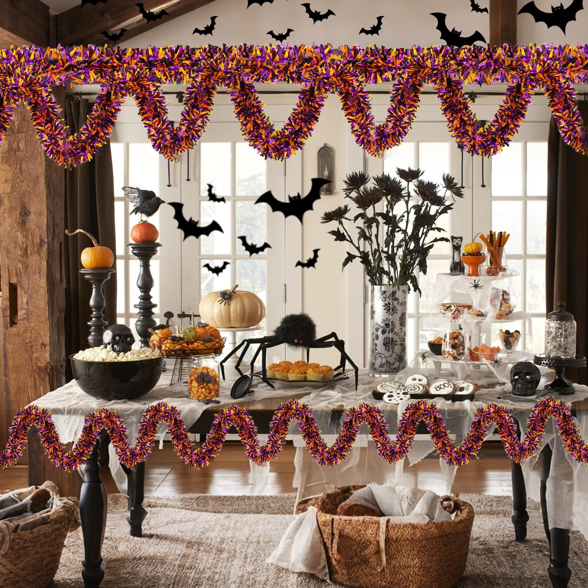Halloween party table decorated with orange, black, and purple tinsel garland, pumpkins, spider, and cookies.
