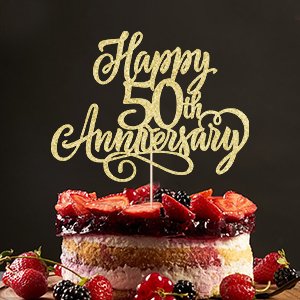 Golden glitter 'Happy 50th Anniversary' cake topper on a fruit-topped cake