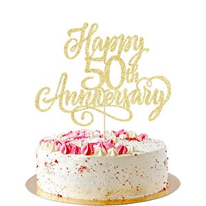 Golden glitter cake topper reading 'Happy 50th Anniversary' on a white frosted cake with pink frosting swirls.