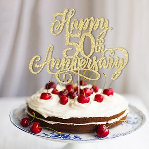 Golden glitter cake topper reading 'Happy 50th Anniversary' on a decorated cake