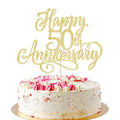 Golden glitter 'Happy 50th Anniversary' cake topper on a decorated cake