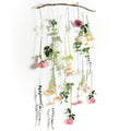 Artificial hanging flower garland with pink, champagne, and white flowers and greenery on a white background.