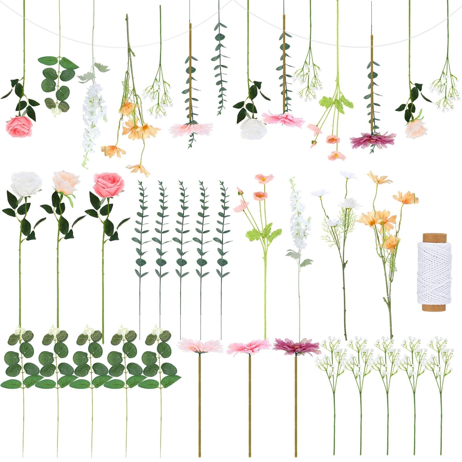 Artificial flowers and greenery with a spool of white twine on a white background