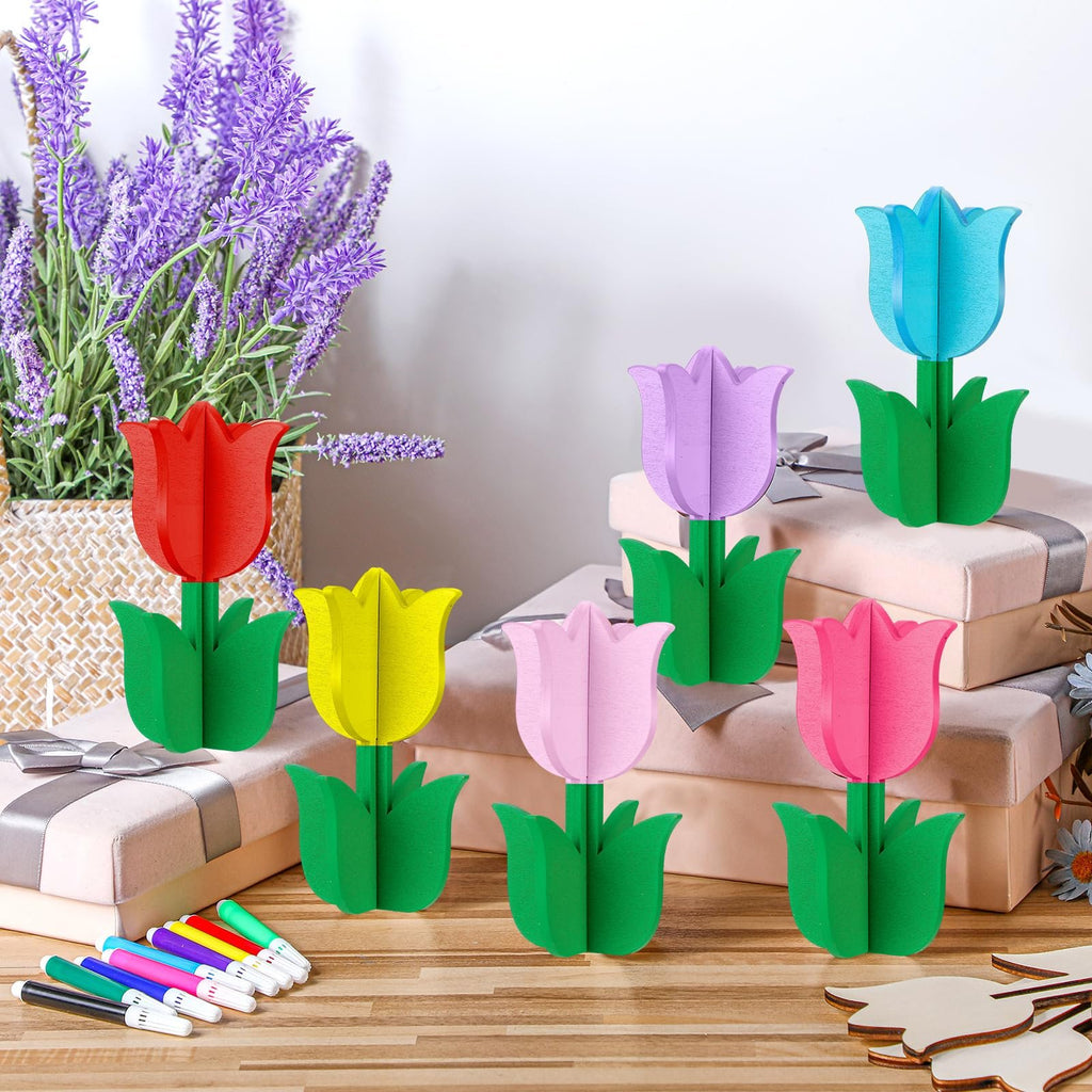 Assortment of colorful wooden tulip craft kits with green stems and leaves, displayed with markers and unfinished wood cutouts.