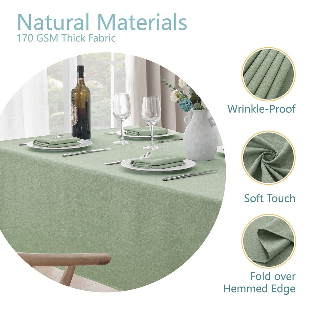 Sage green linen textured tablecloth set for dining, featuring place settings and a wine bottle.