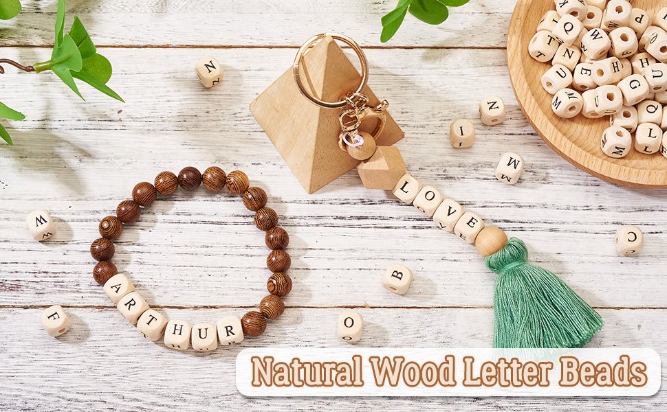 Natural wood alphabet beads spelling 'ARTHUR' and 'LOVE' on a bracelet and keychain, with beads scattered around.