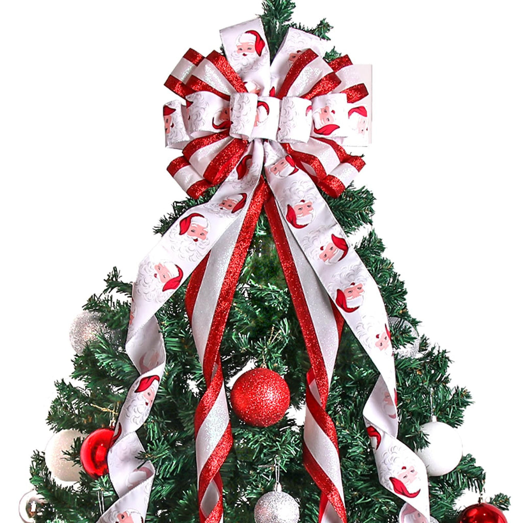 Large red and white Christmas tree topper bow with Santa Claus pattern and glittery ribbon accents, placed on a decorated Christmas tree.