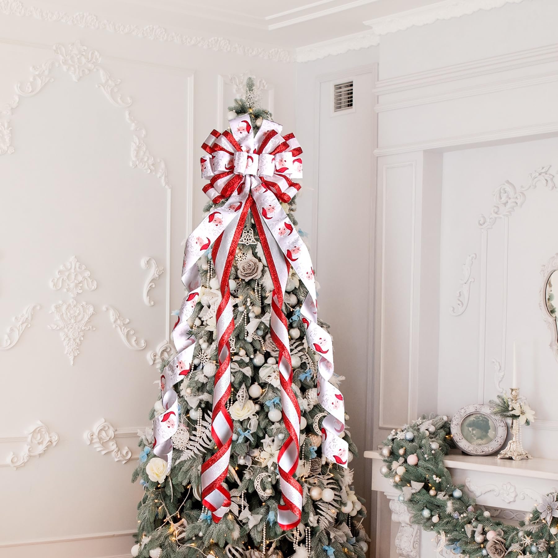 Large white and red Santa Claus patterned bow on top of a decorated Christmas tree