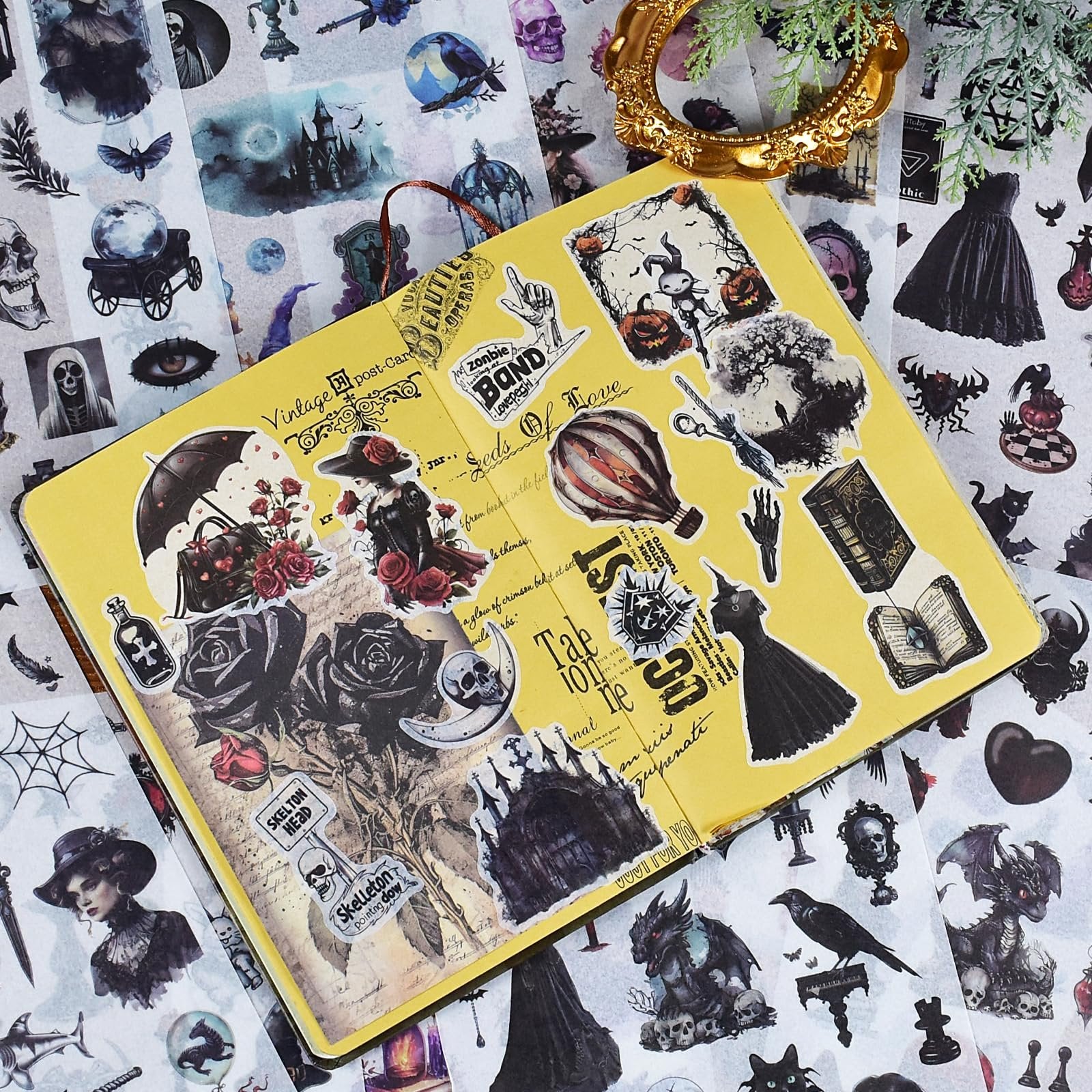 Scrapbook stickers with vintage gothic and floral designs scattered on a yellow notebook and surrounding surface.