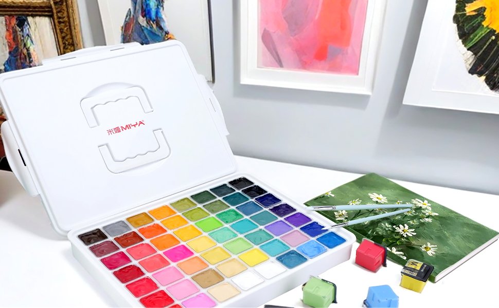 Open gouache paint set with 56 colors in jelly cups, brushes, and a green notebook with daisies.
