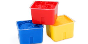 Three gouache paint jelly cups stacked: red on top, blue and yellow below, against a white background.