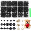 Assorted black safety eyes and noses in a divided container with a green awl and a teddy bear holding a red heart.