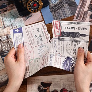 Hands holding torn vintage travel passport stamp stickers for journaling and scrapbooking