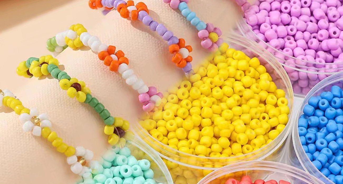 Close-up of colorful seed beads in clear containers and beaded flower bracelets