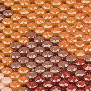 Close-up of a diamond painting canvas with rows of orange and brown faceted resin gems arranged in a pattern.