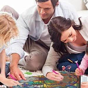 Family working on a 5D butterfly diamond painting kit together on the floor.