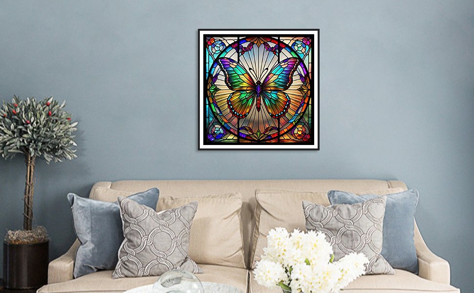 Framed 5D butterfly diamond painting art displayed on a wall above a sofa.