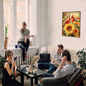 Four people relaxing in a living room with a diamond painting of cardinals and sunflowers hanging on the wall.