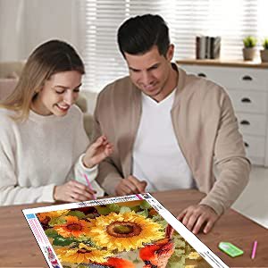Couple working on a 5D cardinal and sunflower diamond painting kit at a table