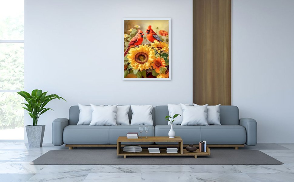 Framed 5D cardinal and sunflower diamond painting art displayed on a living room wall above a sofa.