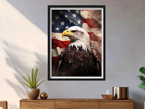 Framed patriotic eagle portrait with American flag background, displayed on a wall above a wooden cabinet.