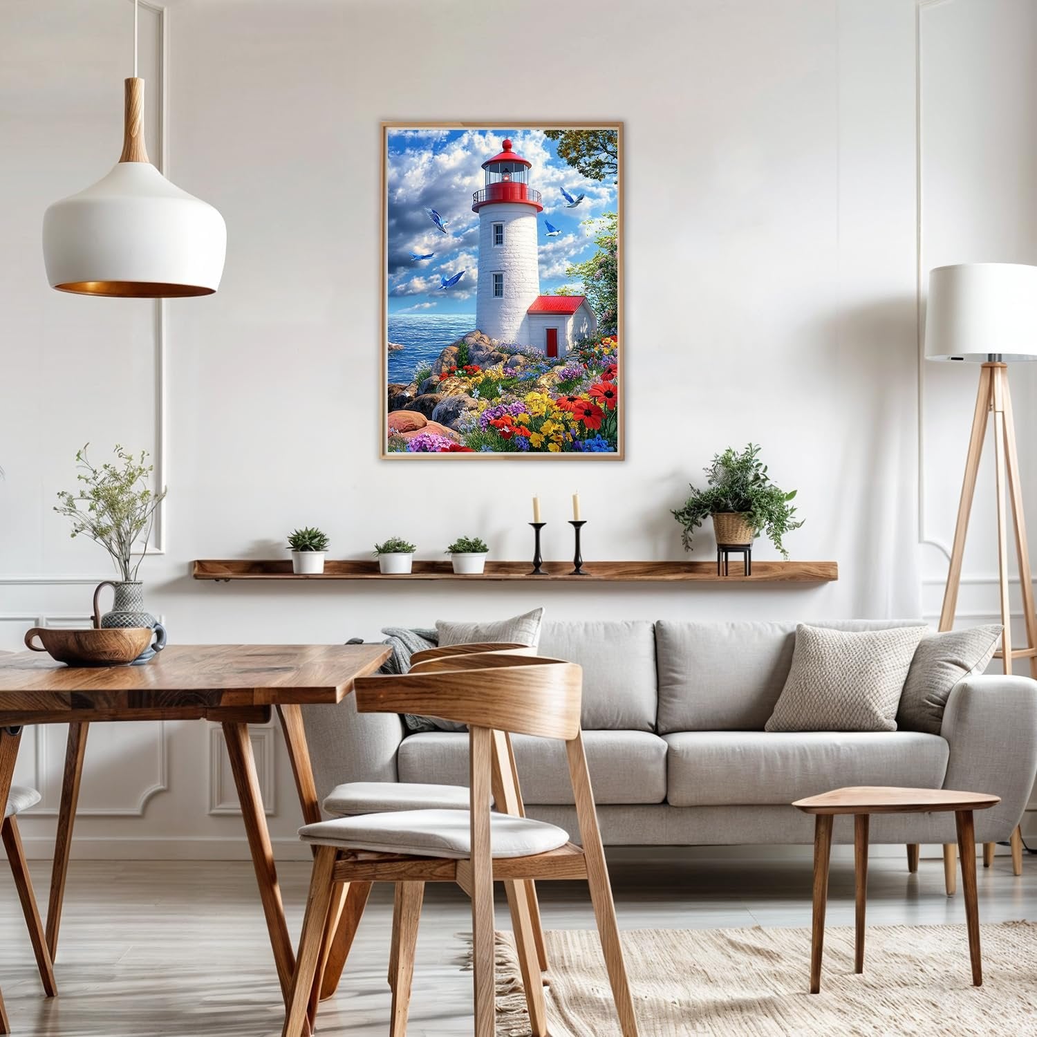 Diamond painting kit of a lighthouse on a rocky shore with flowers and birds, displayed in a living room.