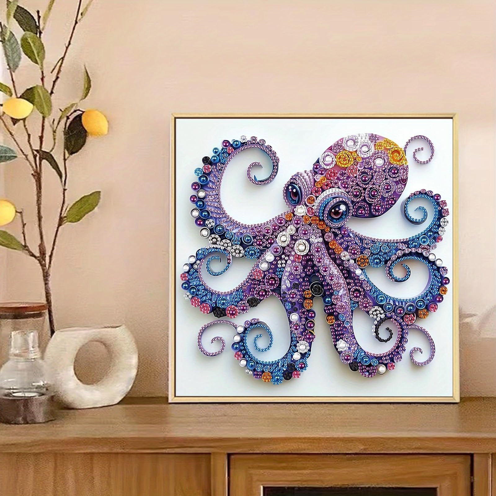 Diamond art painting of a colorful octopus in a gold frame, displayed on a wooden surface with decorative items.