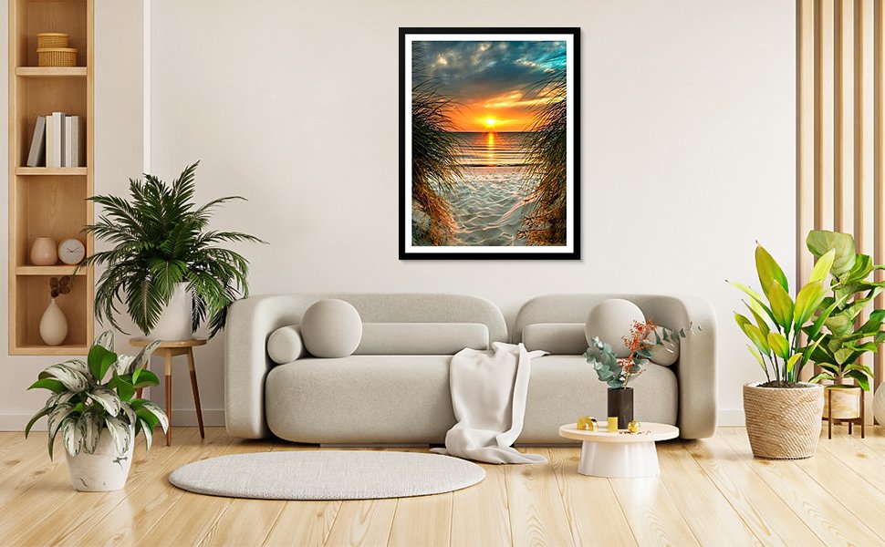 Framed beach sunset diamond painting art hanging on a wall above a sofa in a living room setting.