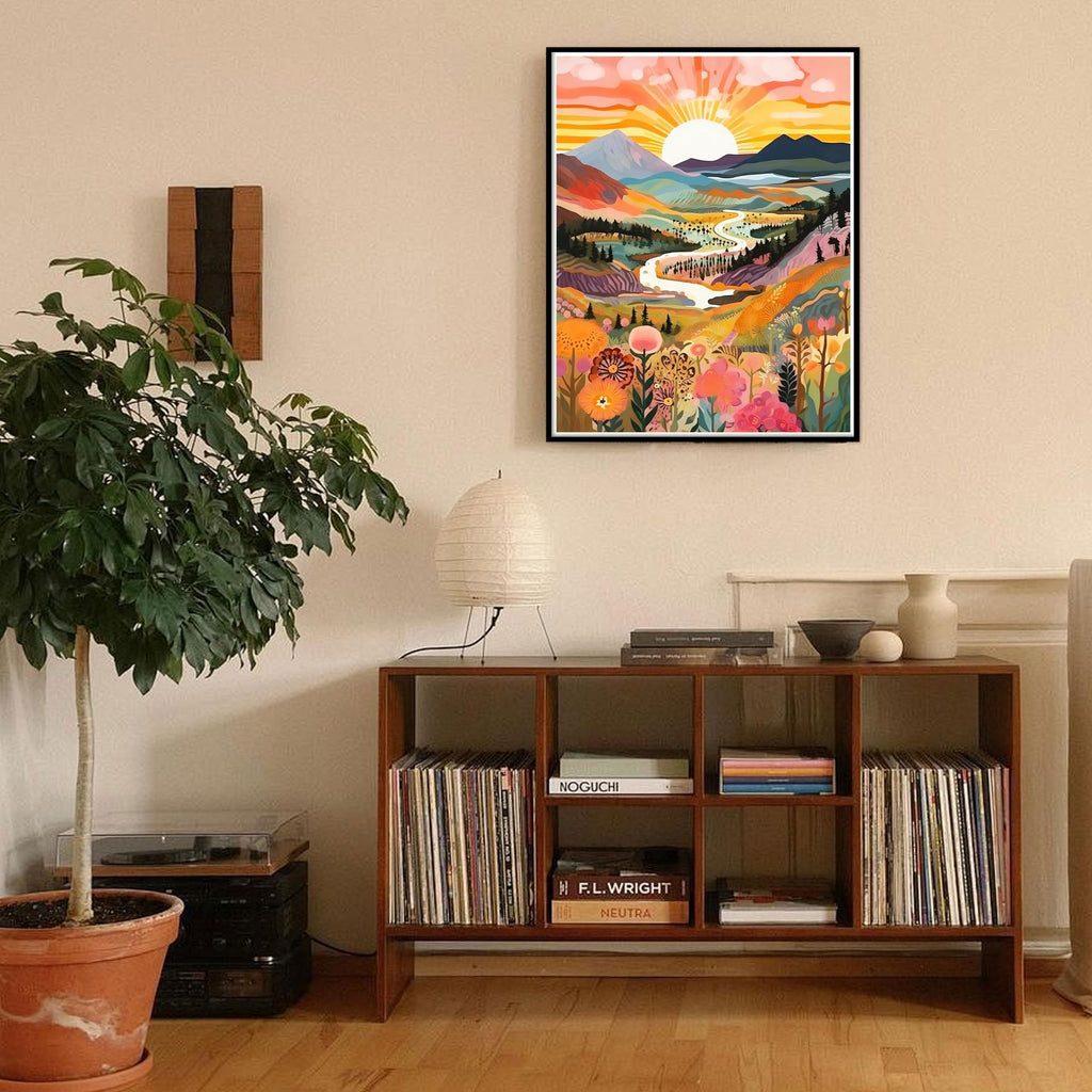 Framed colorful landscape diamond painting of a sunrise over mountains and a river, displayed in a modern living room.