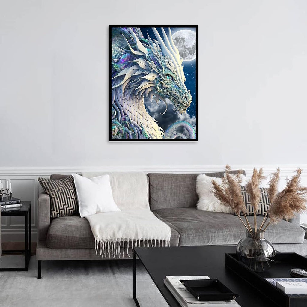 Framed diamond painting of a white dragon with a moon in the background, displayed on a wall above a sofa.