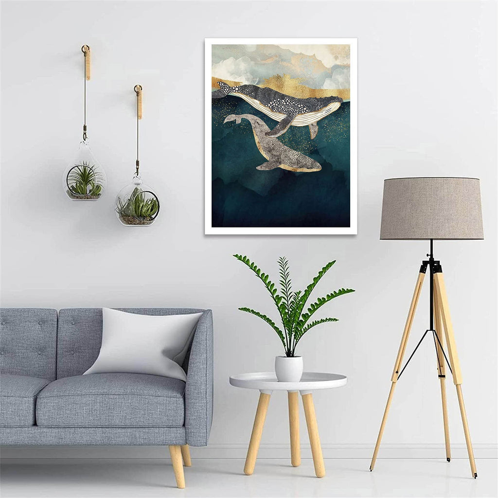 Abstract art print of two whales swimming in dark blue water with gold and white abstract clouds above.