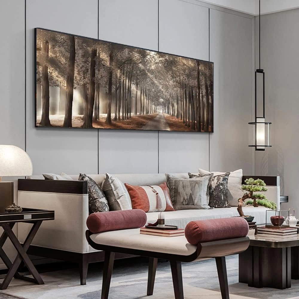 Panoramic wall art of a sunlit forest path with tall trees, displayed above a modern sofa.