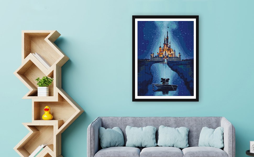 Diamond painting of a castle and two figures in a boat at night, framed and hanging on a wall above a sofa.