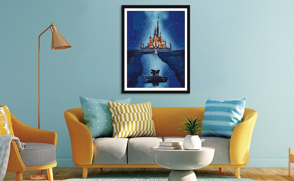 Diamond painting of a castle and a boat with two figures on a starry night sky, framed and hanging above a sofa.