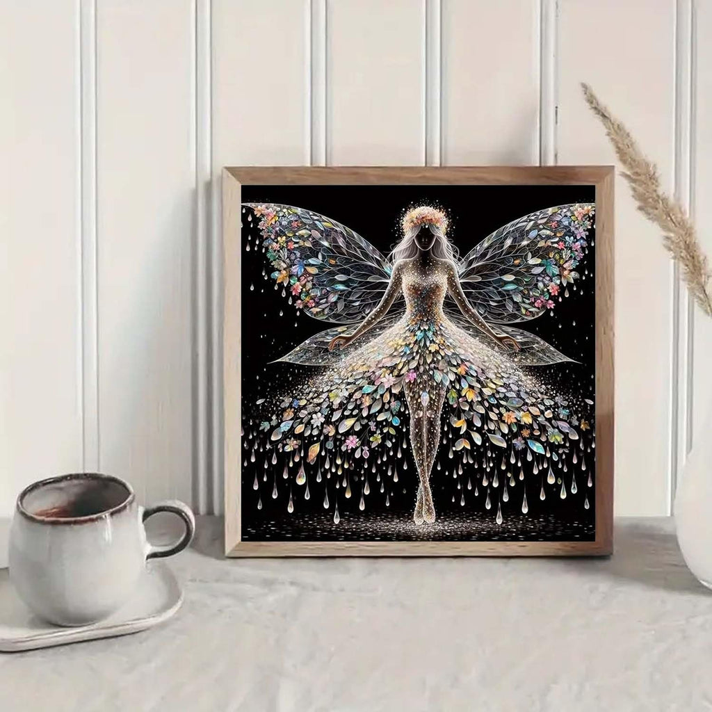 Diamond painting kit featuring a colourful angel wings fairy design, framed and displayed on a shelf with a coffee cup.