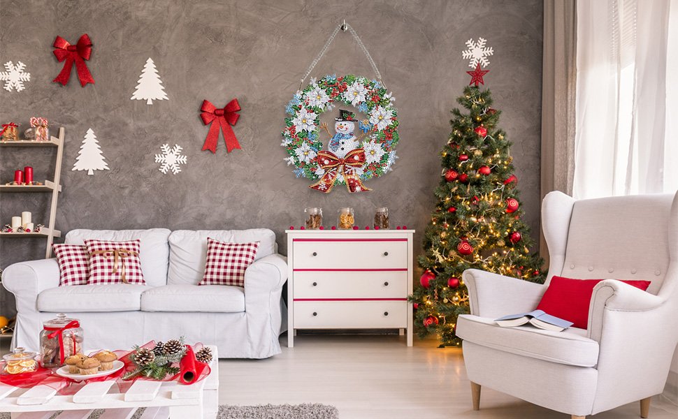 Diamond painting snowman wreath ornament hanging on wall above dresser, with Christmas tree and sofa.