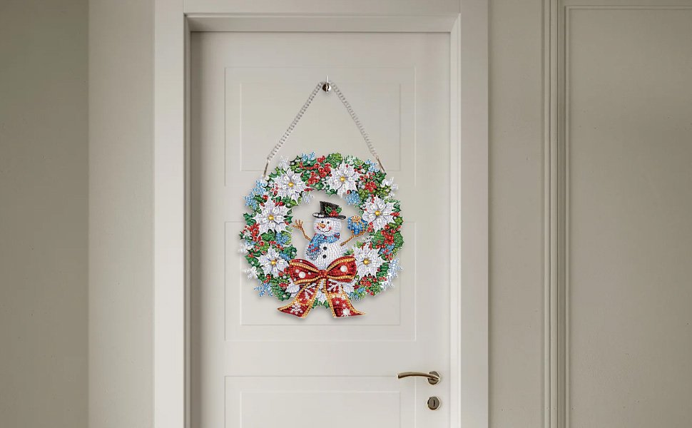 Diamond painting snowman wreath ornament hanging on a white door with a chain and bow