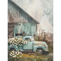 Vintage light blue pickup truck overflowing with white daisies parked in front of a rustic barn