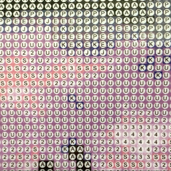 Diamond painting canvas with pre-printed symbols and numbers for placing colored gems, close-up view.