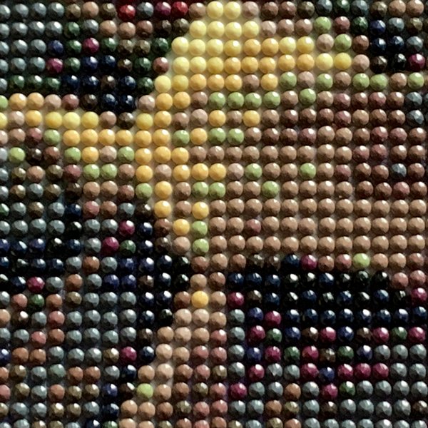 Close-up of a diamond painting kit showing a Halloween Jack design with colorful round drills arranged in a grid pattern.