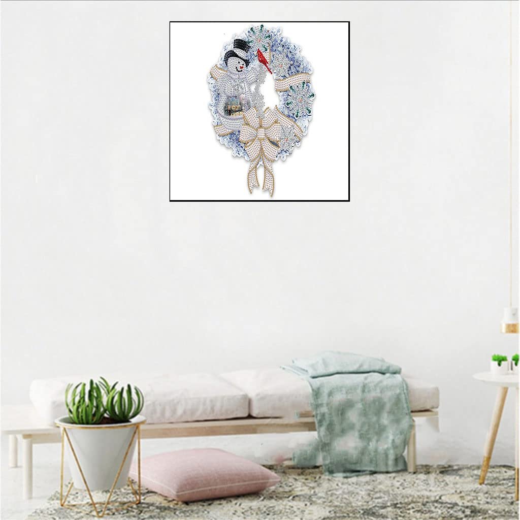 Diamond painting kit of a Christmas wreath with a snowman and bow, displayed on a white wall.
