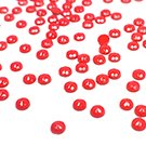 Scattered red diamond painting beads on a white background, close-up shot.