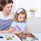Mother and daughter doing a diamond painting kit of desert cactus flowers