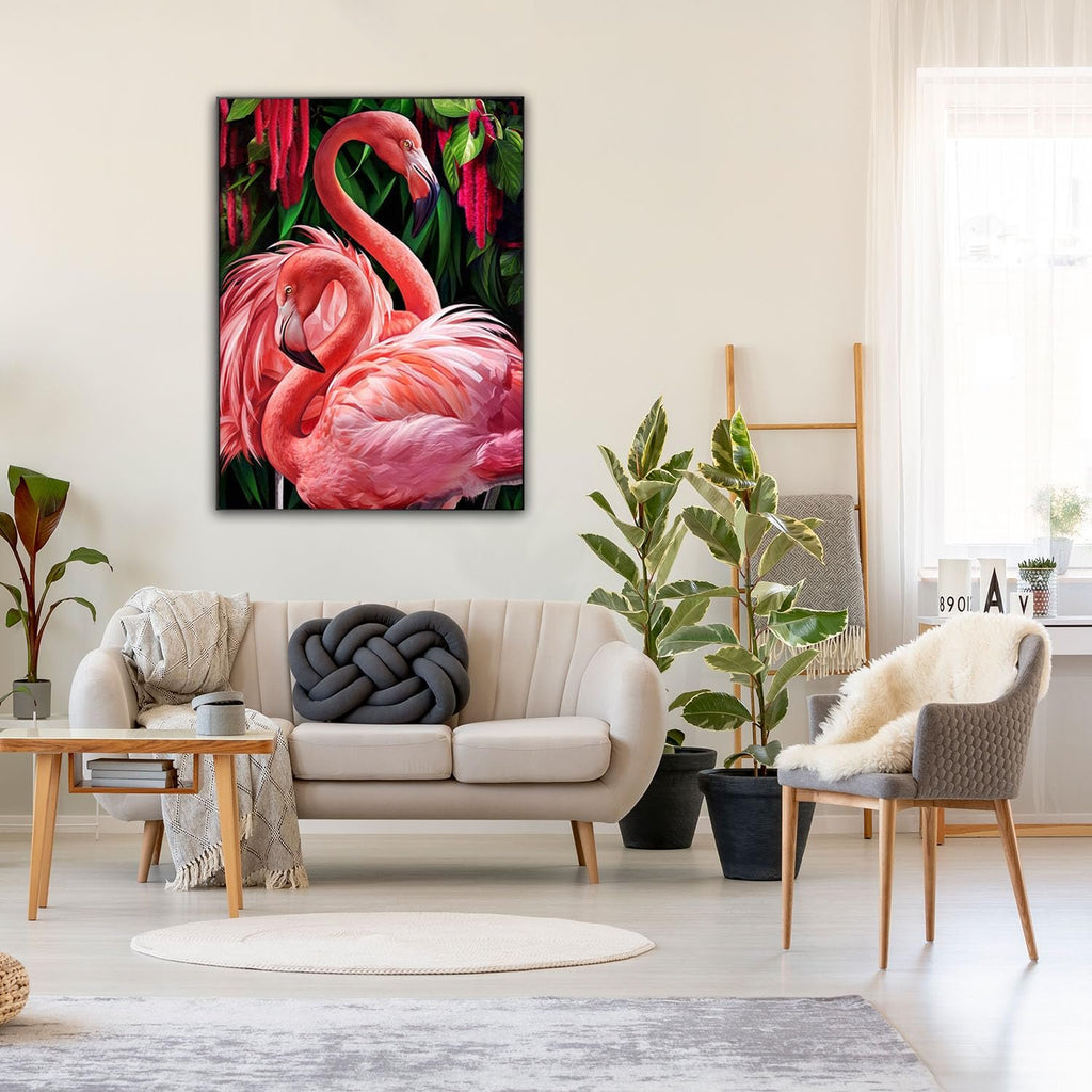 Two pink flamingos nestled together against a backdrop of lush green leaves and red flowers, displayed as wall art in a modern living room.