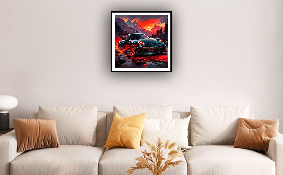 Diamond art painting of a sports car driving on a mountain road at sunset, framed and hanging on a wall above a sofa.