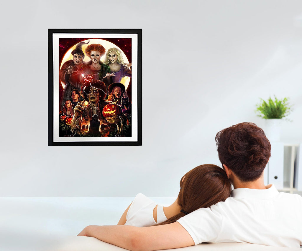 Couple on couch looking at framed Halloween-themed diamond painting art on wall