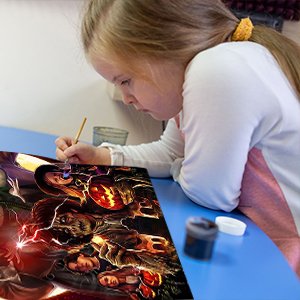 Young girl with Down syndrome painting a Halloween-themed diamond art kit on a blue table